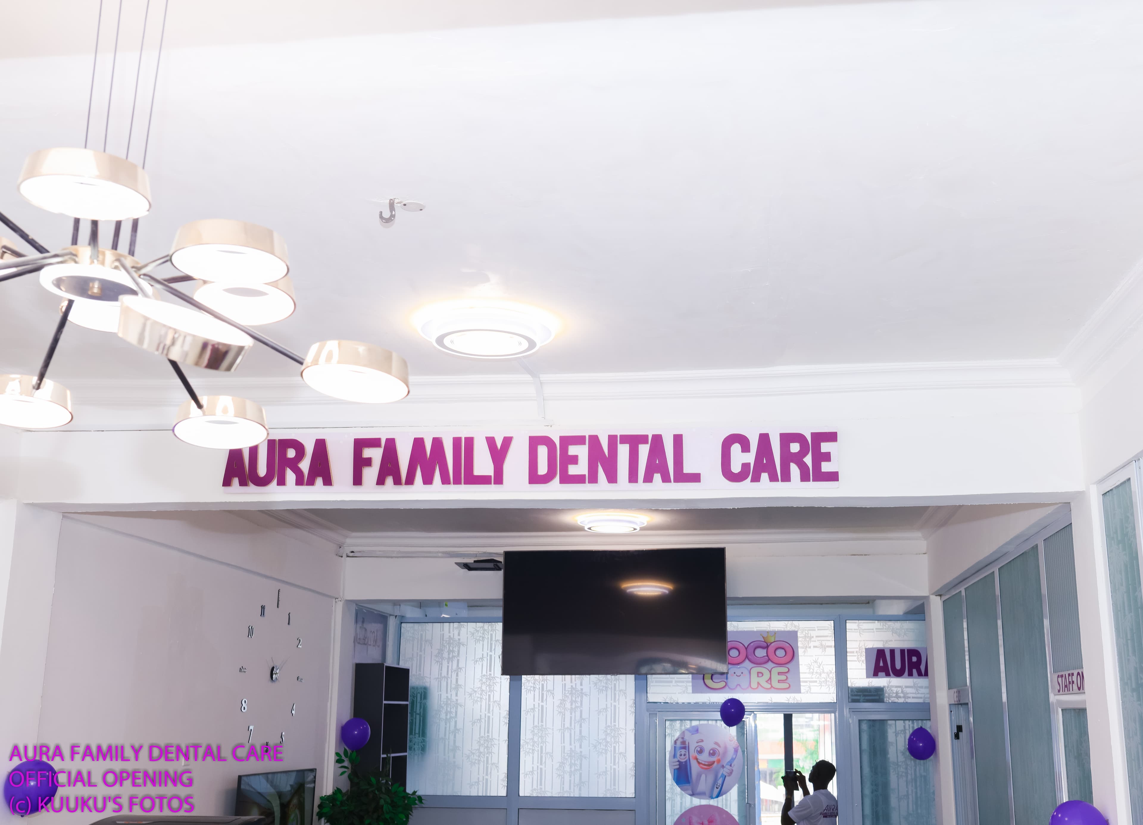Happy Black family laughing together in a bright, modern, family-friendly dental clinic